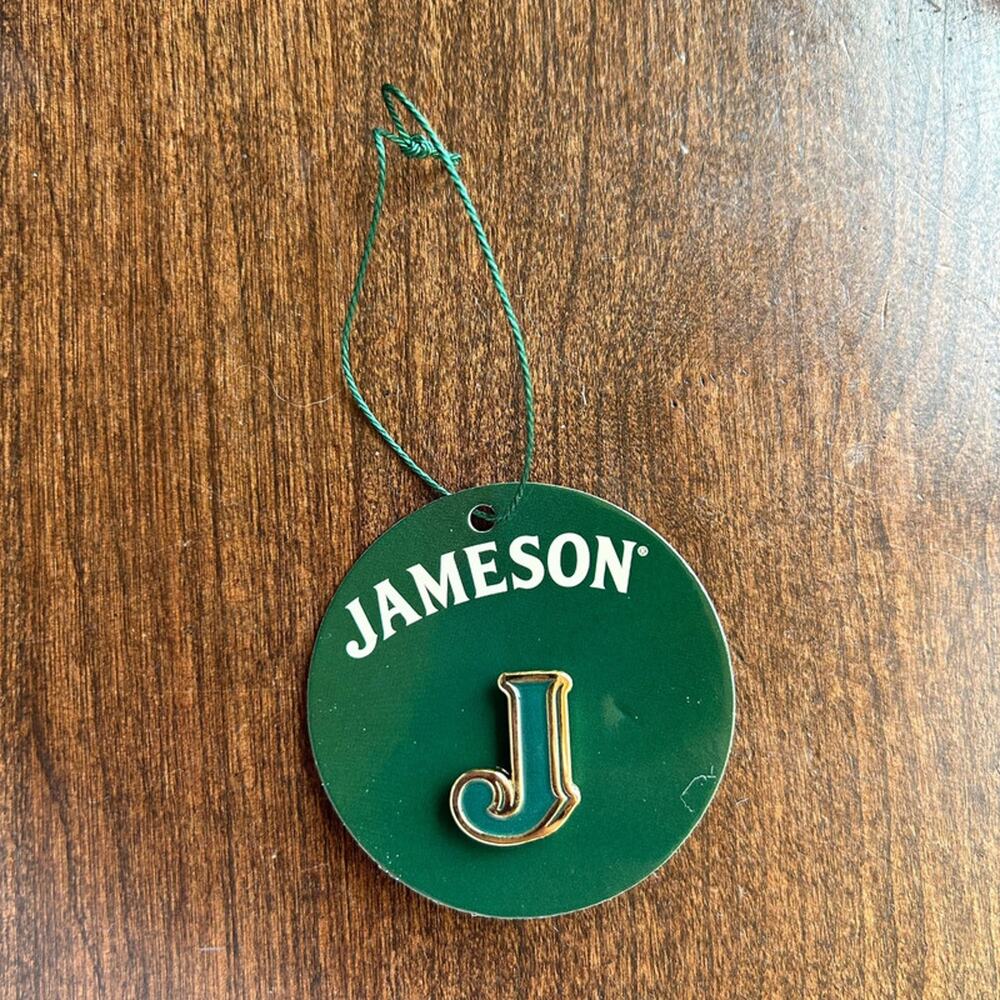 Jameson Irish Whiskey collectible lapel pin featuring a golden-trimmed green "J"